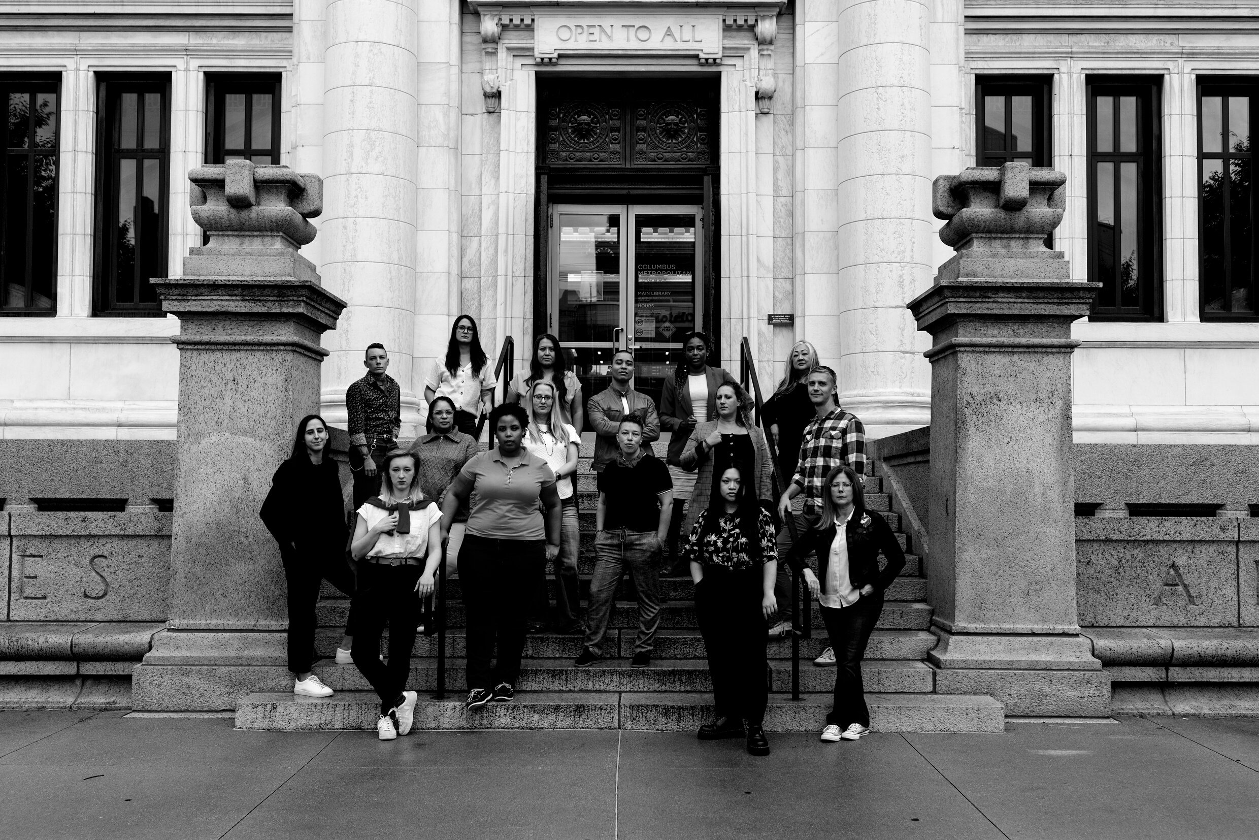 a black and white sign that reads "open to all" in front of a library